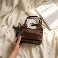 شنطة يد جلد لامع بتصميم بوسطن كلاسيكي وشراشيب | Glossy Leather Boston Bag — Classic Style with Tassel Detail